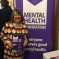 Fiona Bruce MP in front of a purple mental health awareness banner